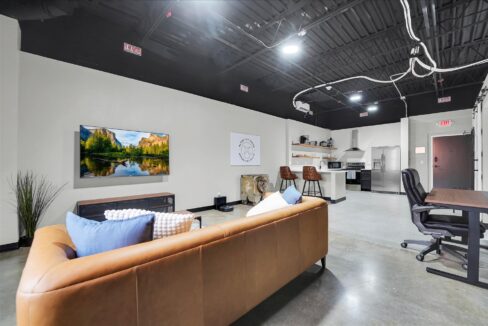 Open concept loft area with living room, kitchen, and study desk in furnished 1-bedroom loft crashpad in Altus OK, ideal temporary military housing near Altus Air Force Base